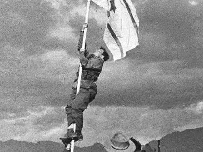 ברן מניף את דגל הדיו בכיבוש אילת, 1949 צילום: מיכה פרי, לע"מ